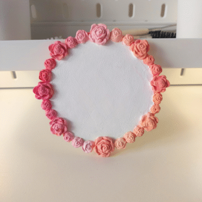 Clay trinket tray with flower edges in a pink to orange sunset gradient handmade