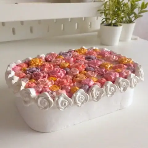 Floral jewelry box filled with tiny pink and yellow flowers on the lid